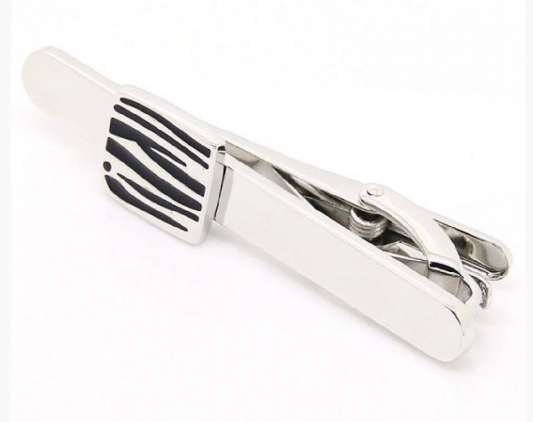 mens tie clip in silver chrome with a black and silver design on the clip