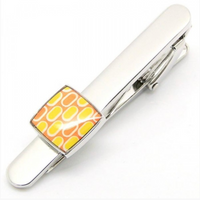 Silver tie clip with an orange and yellow square feature on the end